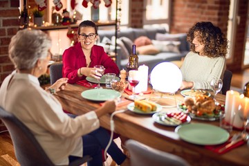 Beautiful group of women smiling happy and confident. Eating roasted turkey celebrating christmas at home