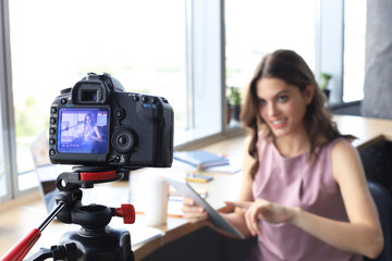 Beautiful young woman talking and smiling while making new video for her blog.