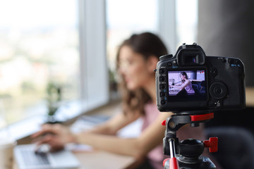 Beautiful young woman talking and smiling while making new video for her blog.