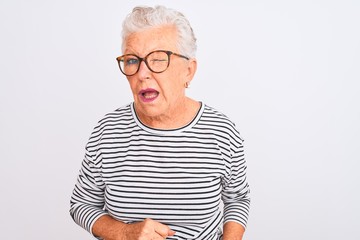 Senior grey-haired woman wearing striped navy t-shirt glasses over isolated white background...