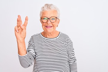 Senior grey-haired woman wearing striped navy t-shirt glasses over isolated white background showing and pointing up with fingers number three while smiling confident and happy.
