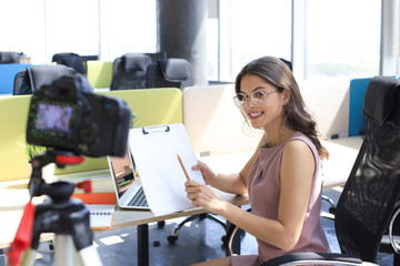 Beautiful young woman talking and smiling while making new video for her blog.
