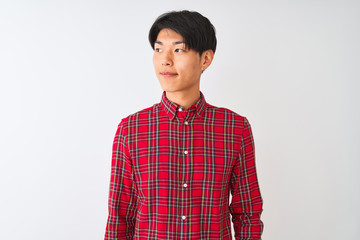 Obraz na płótnie Canvas Young chinese man wearing casual red shirt standing over isolated white background smiling looking to the side and staring away thinking.