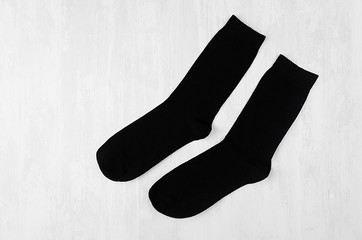 Pair blank black tall socks side view flat lay on white wood board as mock up for design, print,...