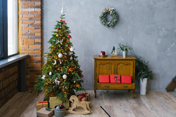Christmas loft style living room interior. Christmas tree with gifts and chest of drawers