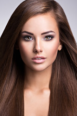 Naklejka premium Portrait of Beautiful young woman with long straight brown hair.