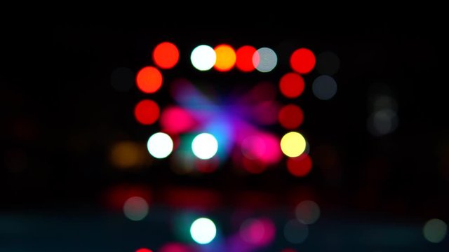 Blurred, defocused night pool party. Color lights reflections in the pool surface. Round bokeh. Beautiful background.
