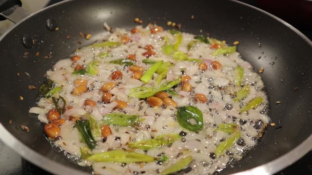 Frying ingredients or veggies in frying pan in hot oil - Concept showing of head fry or Brain fry.