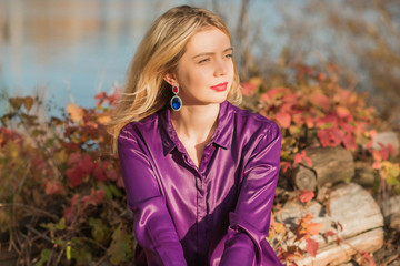 Nice woman, American or European appearance enjoying life. Young lady, stylishly dressed in purple blouse at nature .Natural beauty 