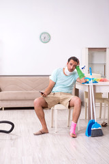 Young injured man cleaning the house