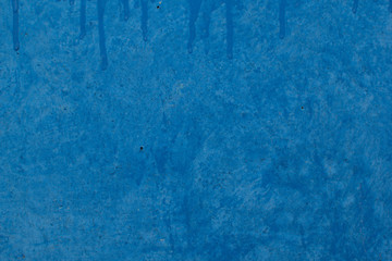 Blue background of old painted wall with streaks of paint