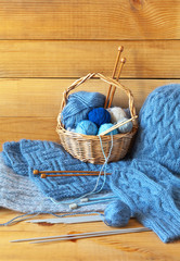 Needlework, knit and craft. Rustic still life with hand-knitted blue warm scarf, mittens, hat and...
