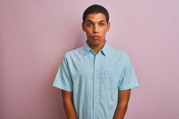 Young handsome arab man wearing blue shirt standing over isolated pink background depressed and worry for distress, crying angry and afraid. Sad expression.