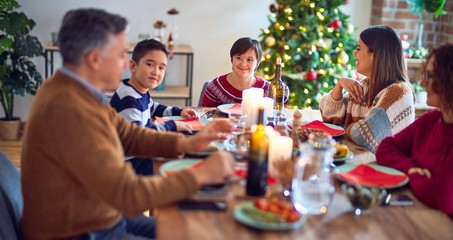 Fototapeta na wymiar Beautiful family smiling happy and confident. Eating roasted turkey celebrating christmas at home