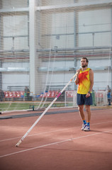 Obraz premium Pole vaulting - man with a beard is standing with a pole