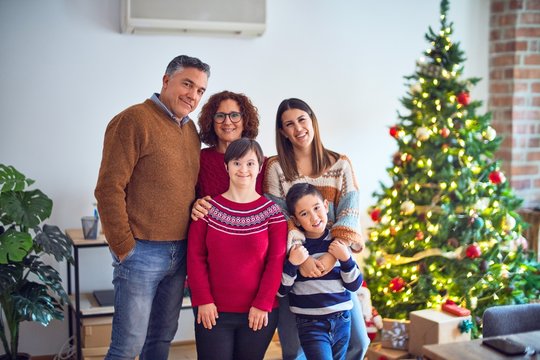 Beautiful family smiling happy and confident. Standing and posing around christmas treeat home