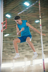 Pole vaulting - man is falling after a jump with a pole and smiling