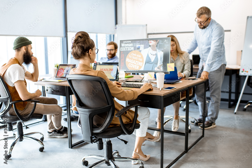 Wall mural group of diverse and creative colleagues working on computers in the modern office or coworking spac