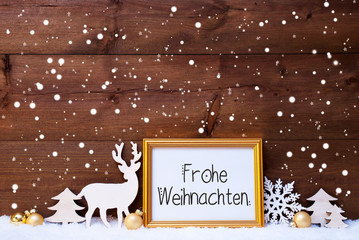 Frame With German Calligraphy Frohe Weihnachten Means Merry Christmas. Golden Decoration Like Ball, Tree And Deer. Wooden Background With Snow And Snowflakes