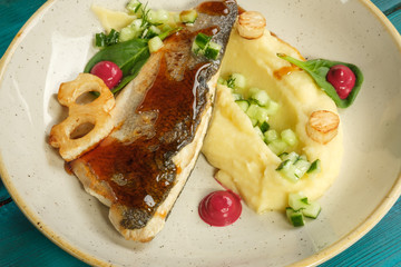 Baked sea bass with mashed potatoes vegetables and herbs