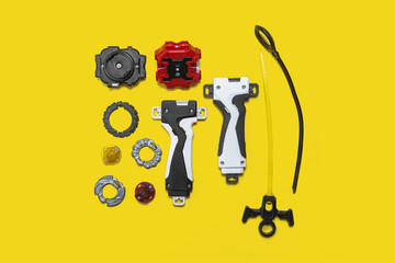 set of kid toys on the yellow surface. Ring, handle, launcher, gyroscope