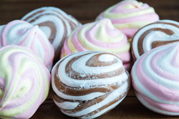 Different colour marshmallow zephyr on wooden background - close up