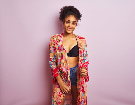 Young beautiful african american woman on vacation standing wearing bikini and colorful caftan