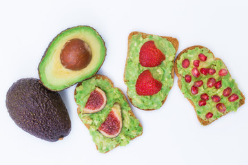 avocado or guacamole toast with natural red fruits
