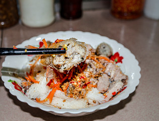 Khmer-Vietnamese noodles fusion food in Toul Tom Pong market( Russian market) in phnom Penh, Cambodia, Ingredients is rice noodle, spring-rolls, pork, carrots and top with ground nuts