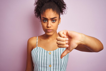 African american woman wearing casual striped dress standing over isolated pink background with...