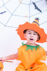 Funny happy kid boy in Halloween costume with pumpkin Jack