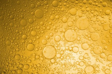 Yellow cooking oil bubble emulsion on background.