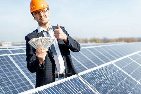 Businessman With Money On A Solar Power Plant