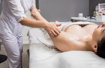 Obraz na płótnie Canvas Beautiful young woman enjoying massage in spa salon. Cosmetology