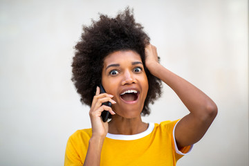 Close up of african american young woman talking on cellphone with surprised expression on face