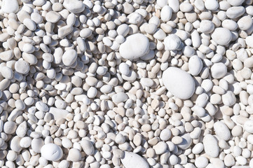 Full frame detail close-up of smooth white Mediterranean pebble beach background in Kefalonia, Greece