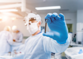 Spinal surgery. Surgeon show polyaxial screw in operating room with surgery equipment. Laminectomy....