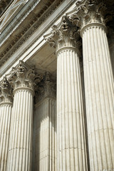 Close-up detail view of classical architectural fluted columns with Corinthian capitals featuring iconic carved acanthus foliage