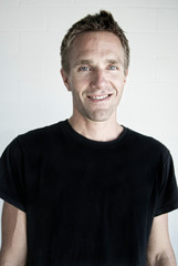 Portrait of cheerful man in black T-shirt smiling at the camera