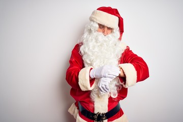 Middle age handsome man wearing Santa costume standing over isolated white background Checking the time on wrist watch, relaxed and confident