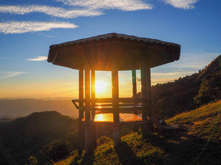 The golden light of the evening sun shone through the empty pavilions of the pavilions. Phu Pu mountain and the pavilion are a black silhouette, Sop Moei, Mae Hong Son, Thailand.