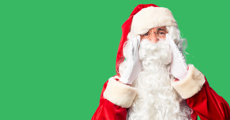 Fototapeta na wymiar Middle age handsome man wearing Santa Claus costume and beard standing Shouting angry out loud with hands over mouth