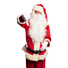 Middle age handsome man wearing Santa Claus costume and beard standing looking unhappy and angry showing rejection and negative with thumbs down gesture. Bad expression.