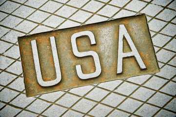 Solid industrial "USA" message cast into a textured steel background with rust and imperfections