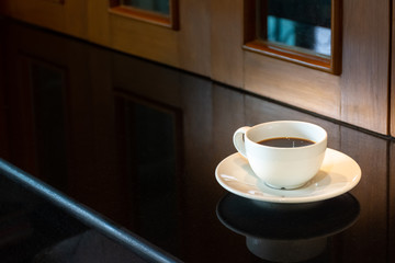 Mockup hot black coffee in white ceramic cup isolated on dark marble table background. Healthy...