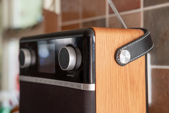 Modern, DAB and digital streaming radio seen located in a kitchen. The modern design, wooden cabinet and push buttons are visible on this radio set.