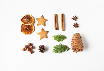 Flat lay Christmas composition - star cookie, cinnamon, anise star, nuts, dry orange slices, anise star, pine cone and fir branches on white background. top view,