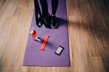 Person standing on purple mat with smartphone sport accessories