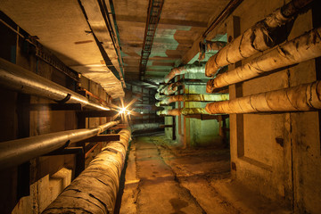 Underground concrete utility tunnel with pipes and wires. This tunnel gives energy, water and heat...