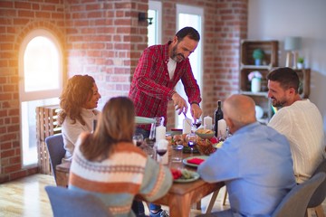 Beautiful family smiling happy and confident. Carving roasted turkey celebrating Thanksgiving Day at home